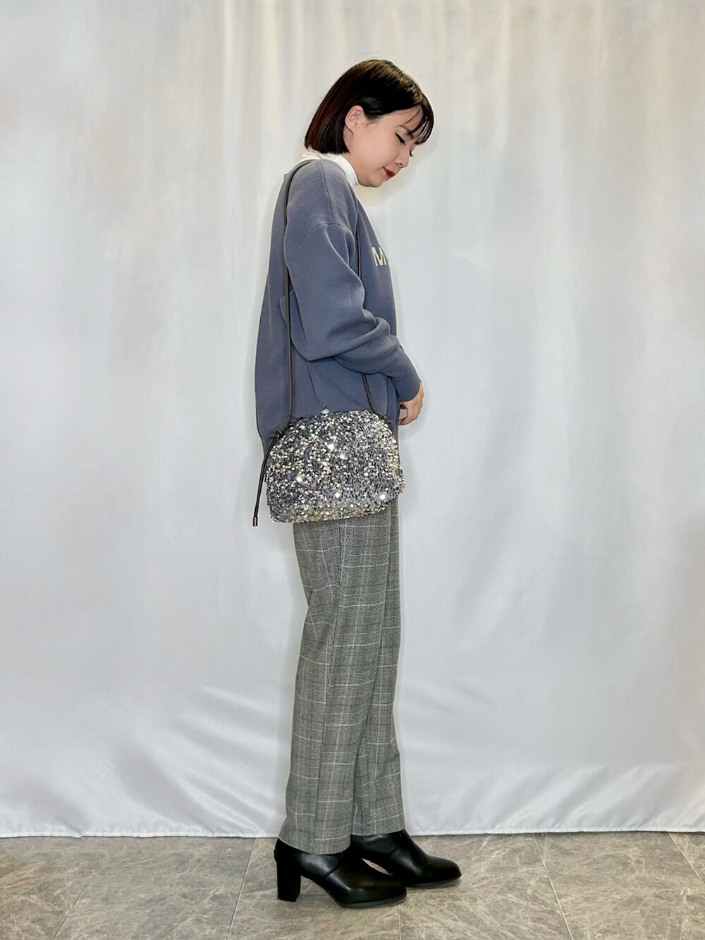 ブラック系のブーツ、グレー系のその他パンツ、シルバー系のショルダーバッグを着用したレディースの秋コーディネートの2枚目の写真