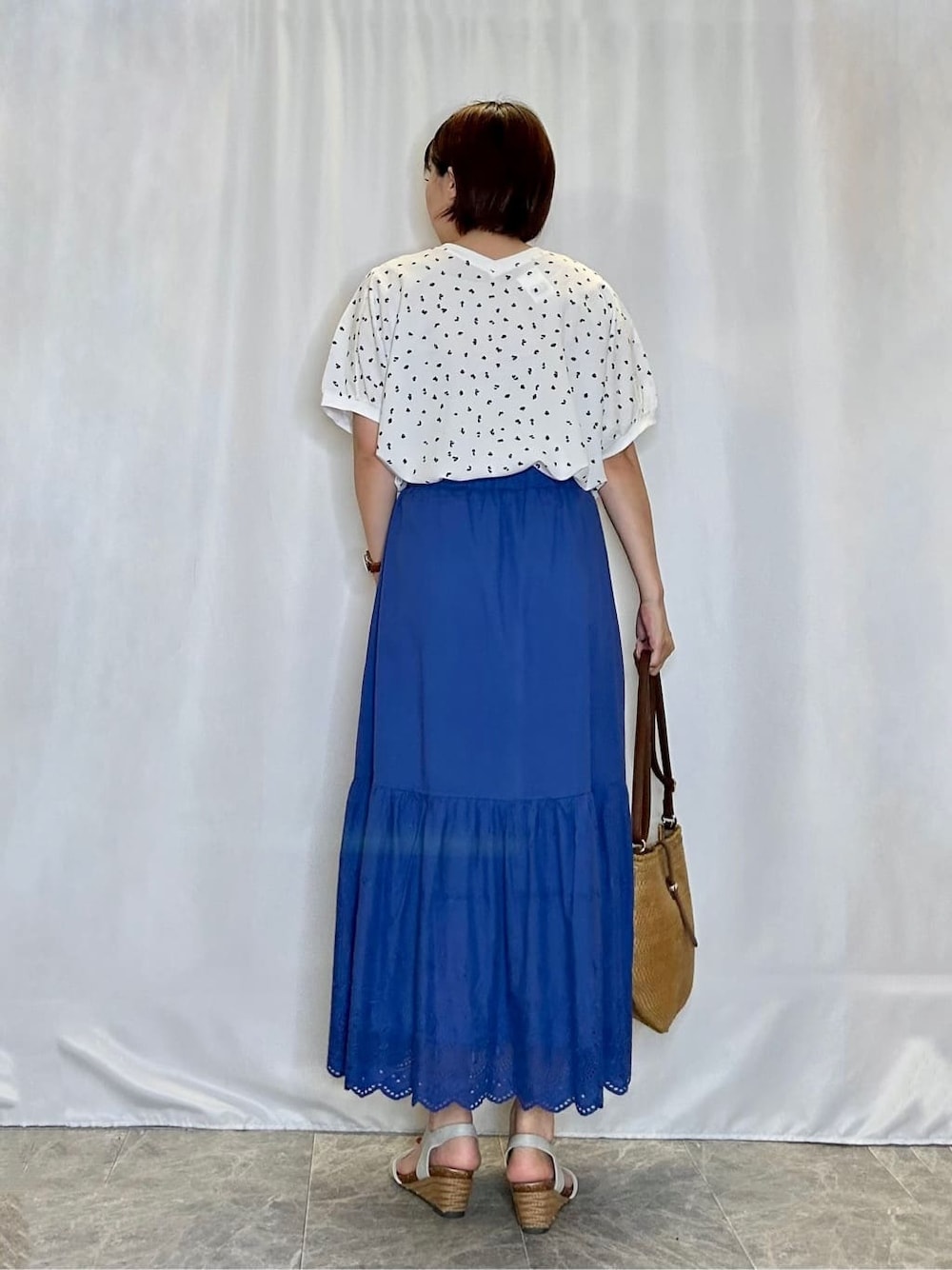 ホワイト系のシャツ/ブラウス、ブルー系のスカート、シルバー系のサンダルを着用したレディースの夏コーディネートの3枚目の写真