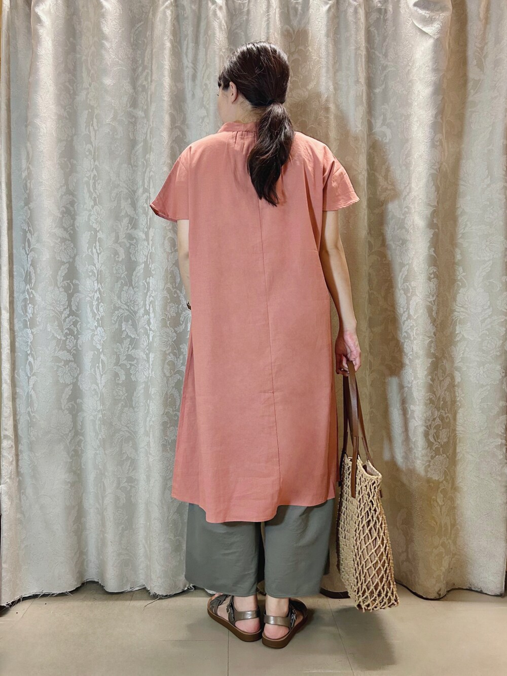 ピンク系のワンピース、ブラウン系のトートバッグ、その他のサンダルを着用したレディースの夏コーディネートの3枚目の写真