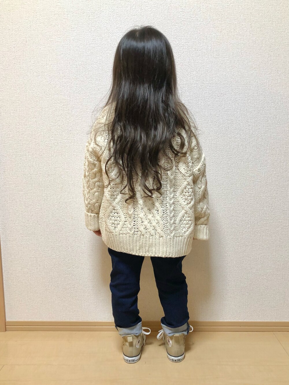 レッド系のニット/セーター、ホワイト系のカーディガン/ボレロ、ブルー系のその他パンツを着用したレディースの秋コーディネートの3枚目の写真