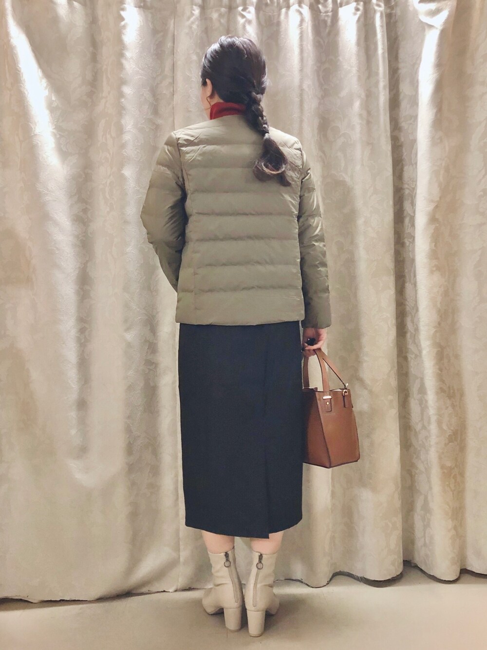 グリーン系のダウンジャケット/コート、ブラック系のスカート、イエロー系のショルダーバッグを着用したレディースの秋コーディネートの3枚目の写真