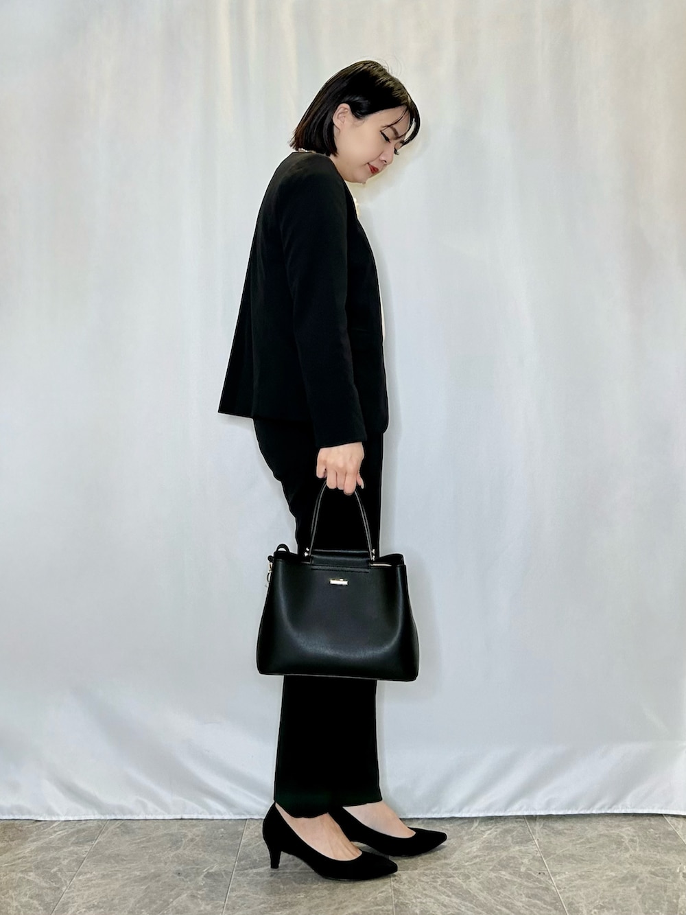 ブラック系のパンプス、ホワイト系のシャツ/ブラウス、ブラック系のトートバッグを着用したレディースの冬コーディネートの2枚目の写真