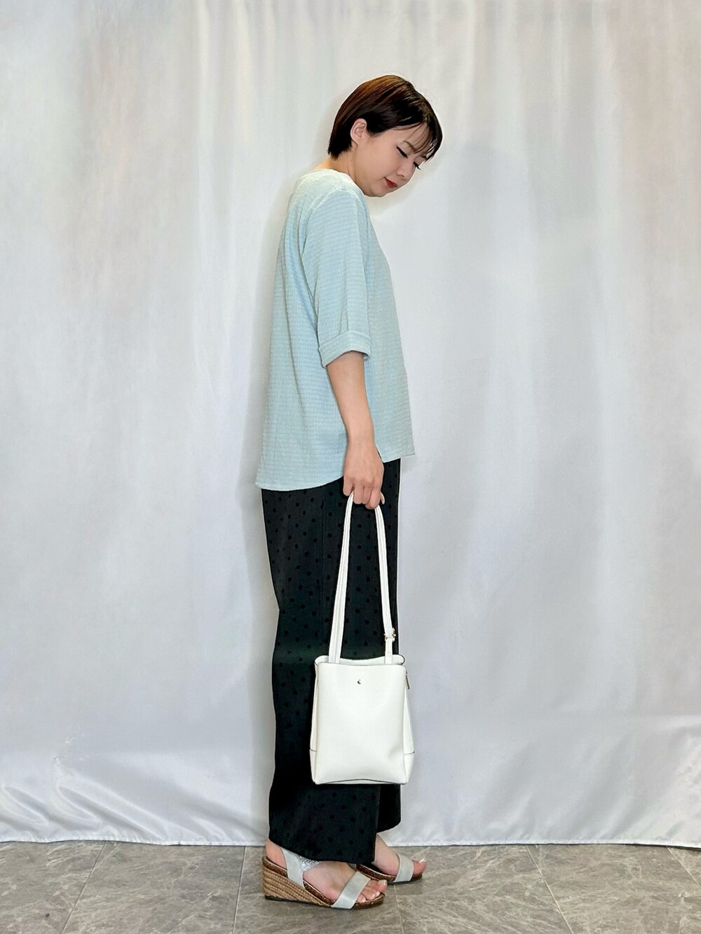 グレー系のその他パンツ、シルバー系のサンダル、ブルー系のTシャツ/カットソーを着用したレディースの春コーディネートの2枚目の写真