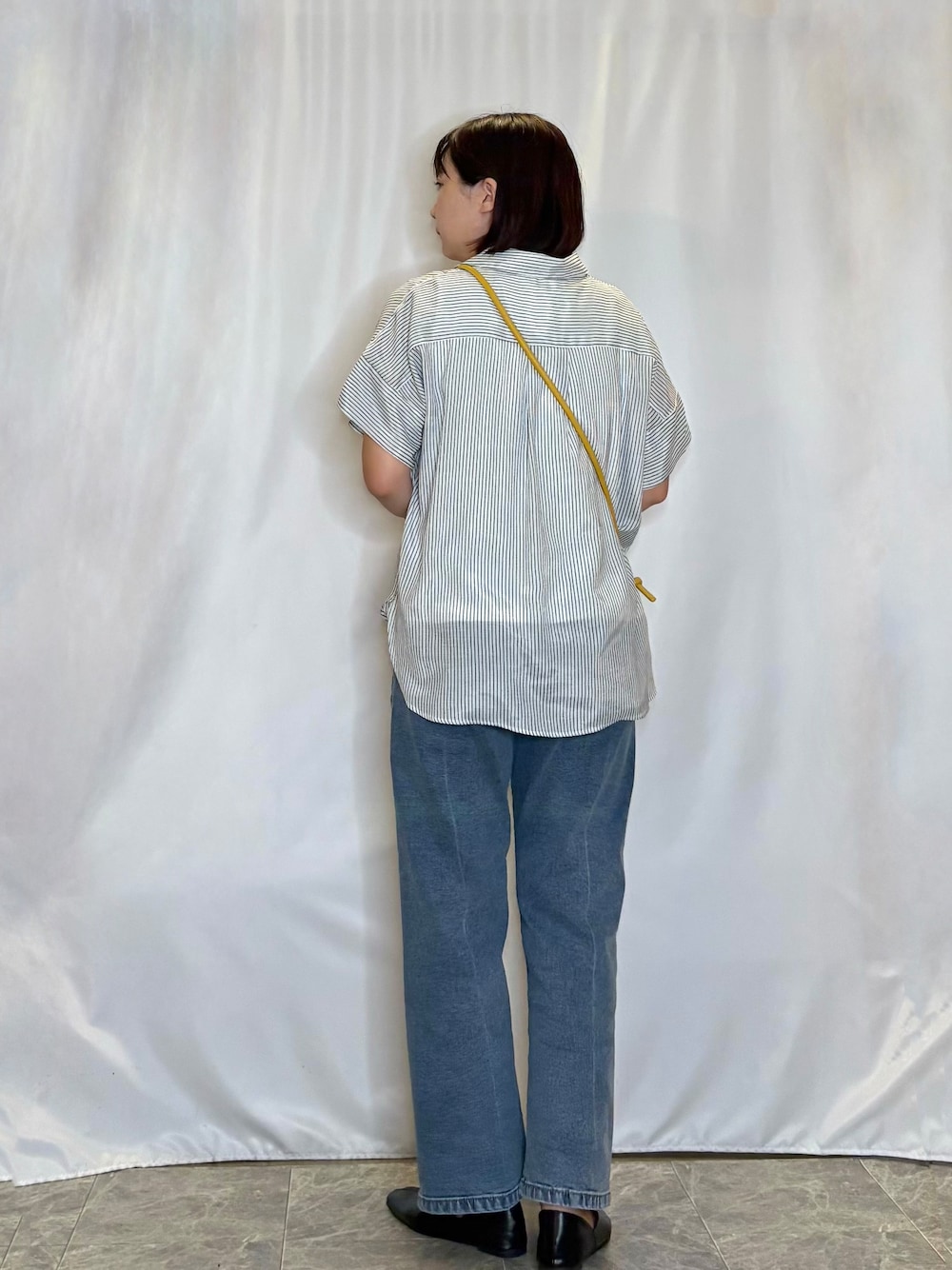 ホワイト系のその他トップス、ブルー系のデニムパンツ、イエロー系のショルダーバッグを着用したレディースの秋コーディネートの3枚目の写真