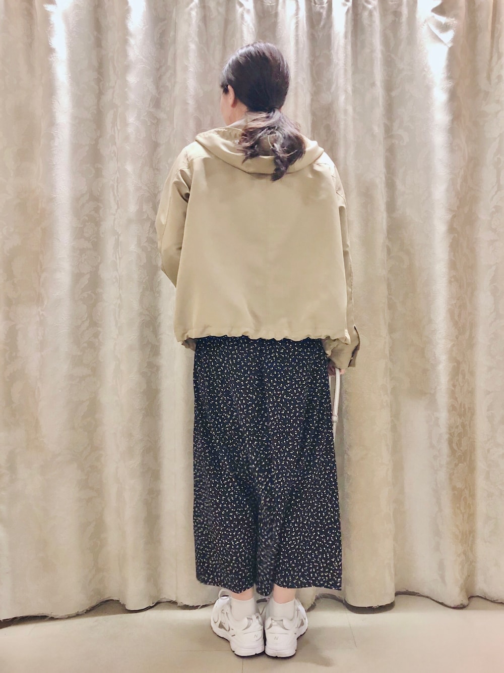 オレンジ系のニット/セーター、ベージュ系のブルゾン、シルバー系のショルダーバッグを着用したレディースの春コーディネートの3枚目の写真