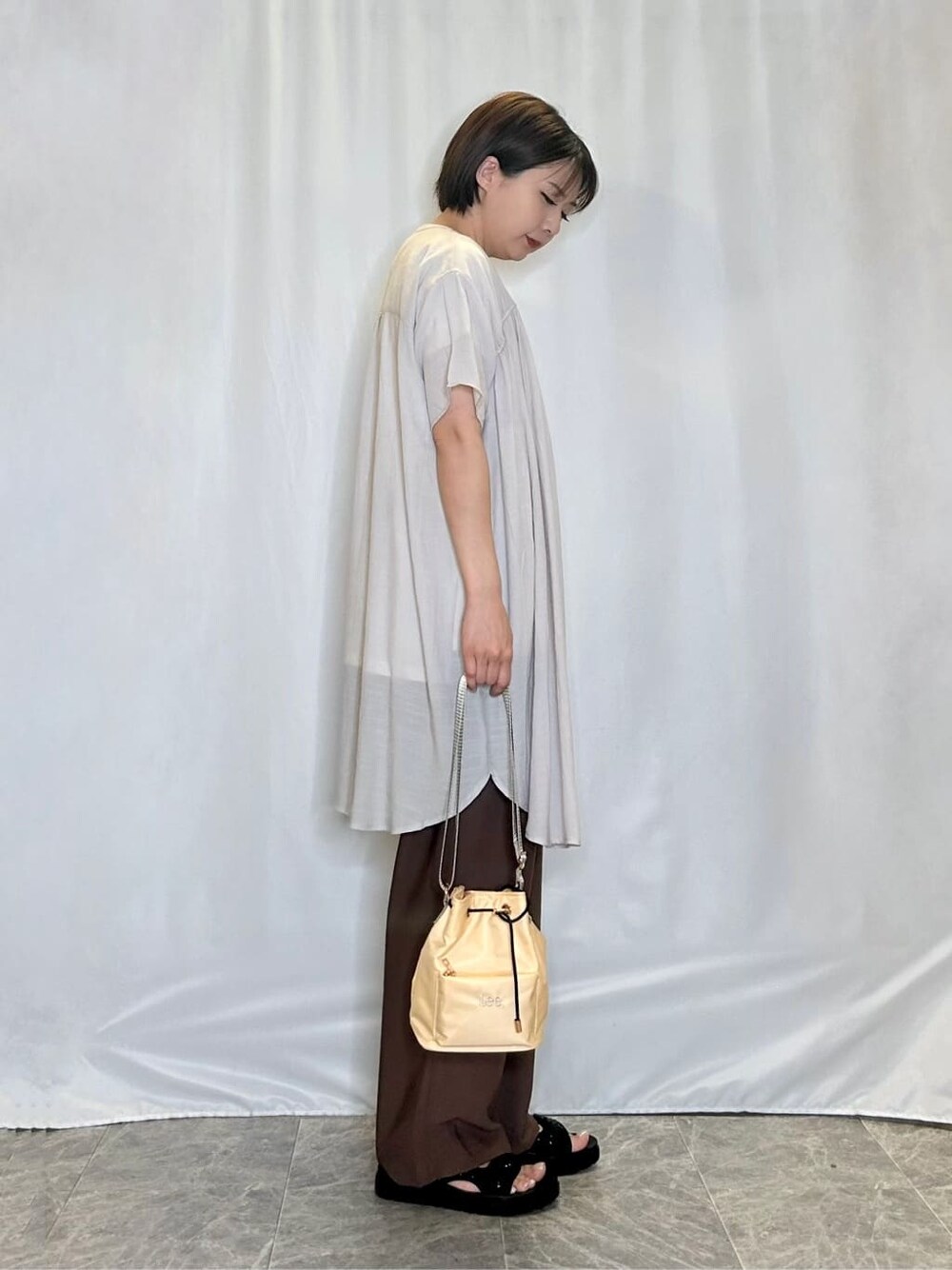 ベージュ系のチュニック、ホワイト系のTシャツ/カットソー、ブラウン系のその他パンツを着用したレディースの夏コーディネートの2枚目の写真
