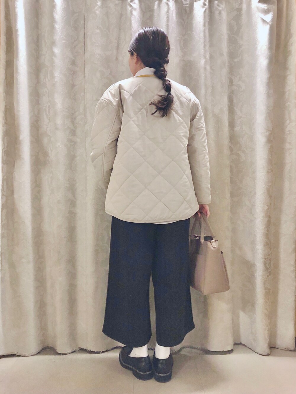 ベージュ系のトートバッグ、ブラック系のドレスシューズ、ブラック系のその他パンツを着用したレディースの冬コーディネートの3枚目の写真