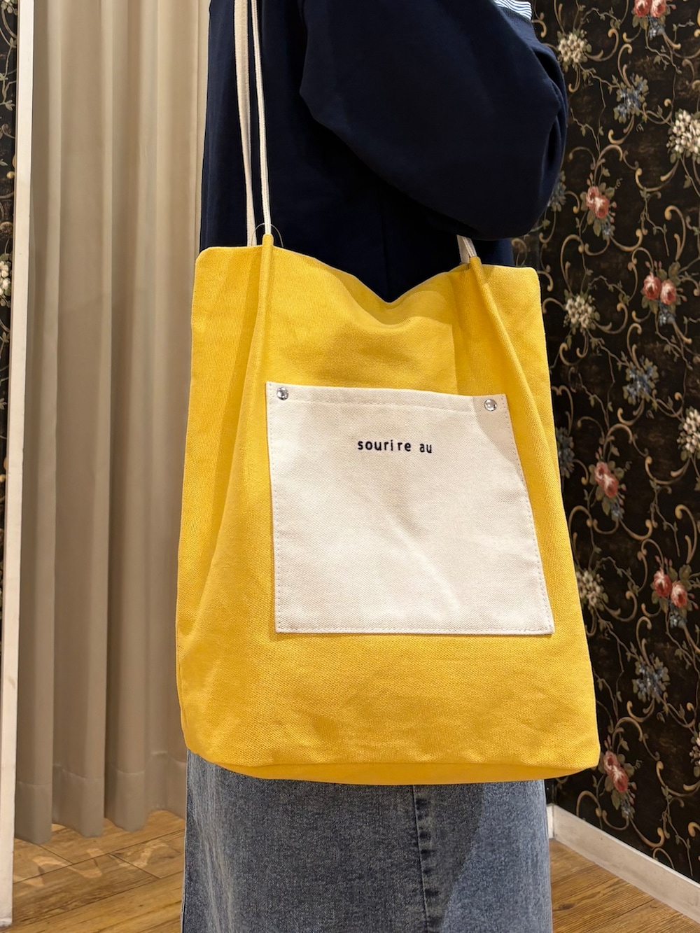 ブルー系のTシャツ/カットソー、ブルー系のデニムスカート、イエロー系のトートバッグを着用したレディースの秋コーディネートの5枚目の写真