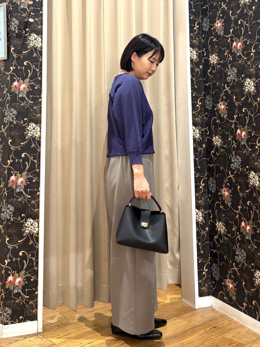 ブルー系のニット/セーター、ベージュ系のその他パンツ、ブラック系のショルダーバッグを着用したレディースの秋コーディネートの2枚目の写真