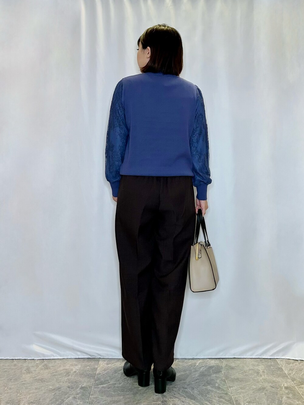 ブラック系のブーツ、ベージュ系のトートバッグ、ブラウン系のその他パンツを着用したレディースの秋コーディネートの3枚目の写真