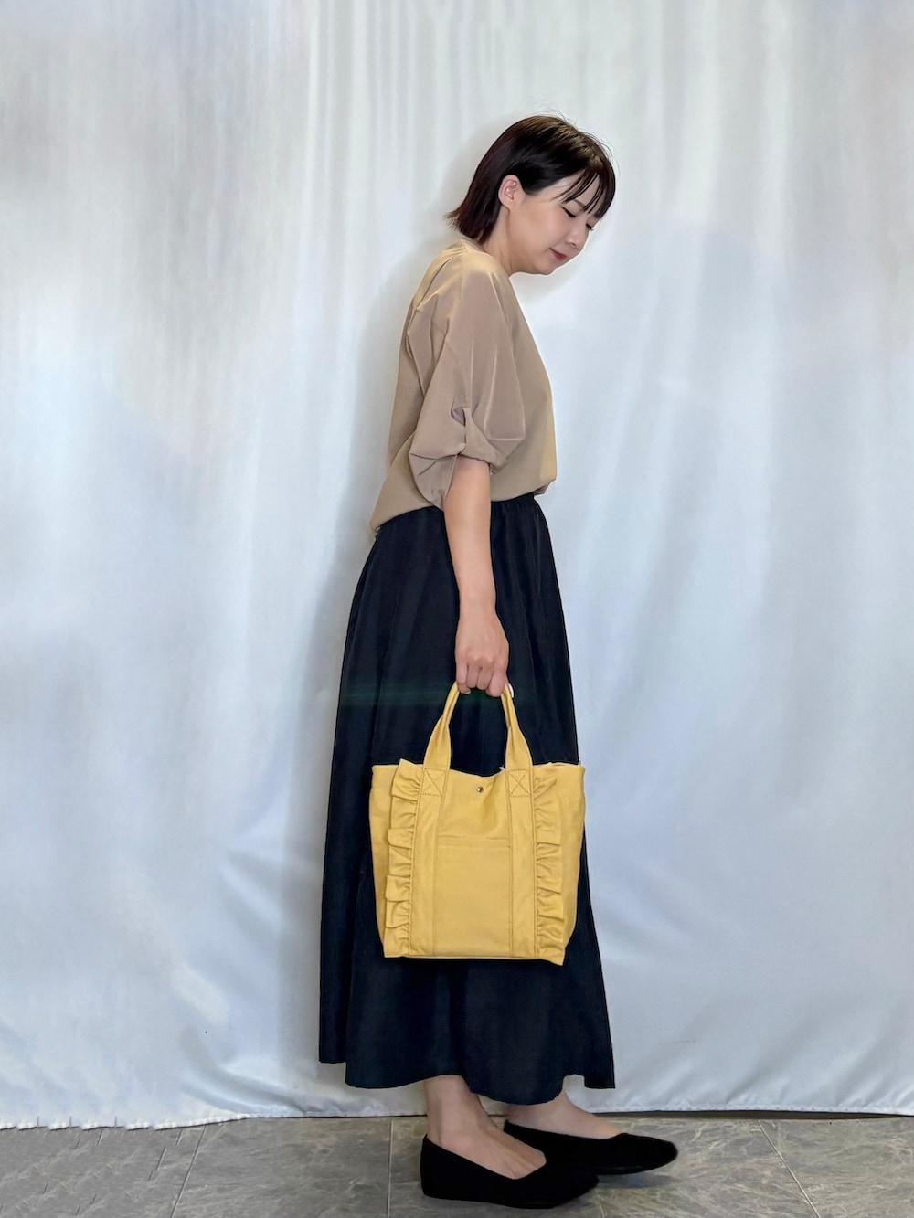 ブラウン系のTシャツ/カットソー、ブルー系のスカート、ブラック系のパンプスを着用したレディースの夏コーディネートの3枚目の写真