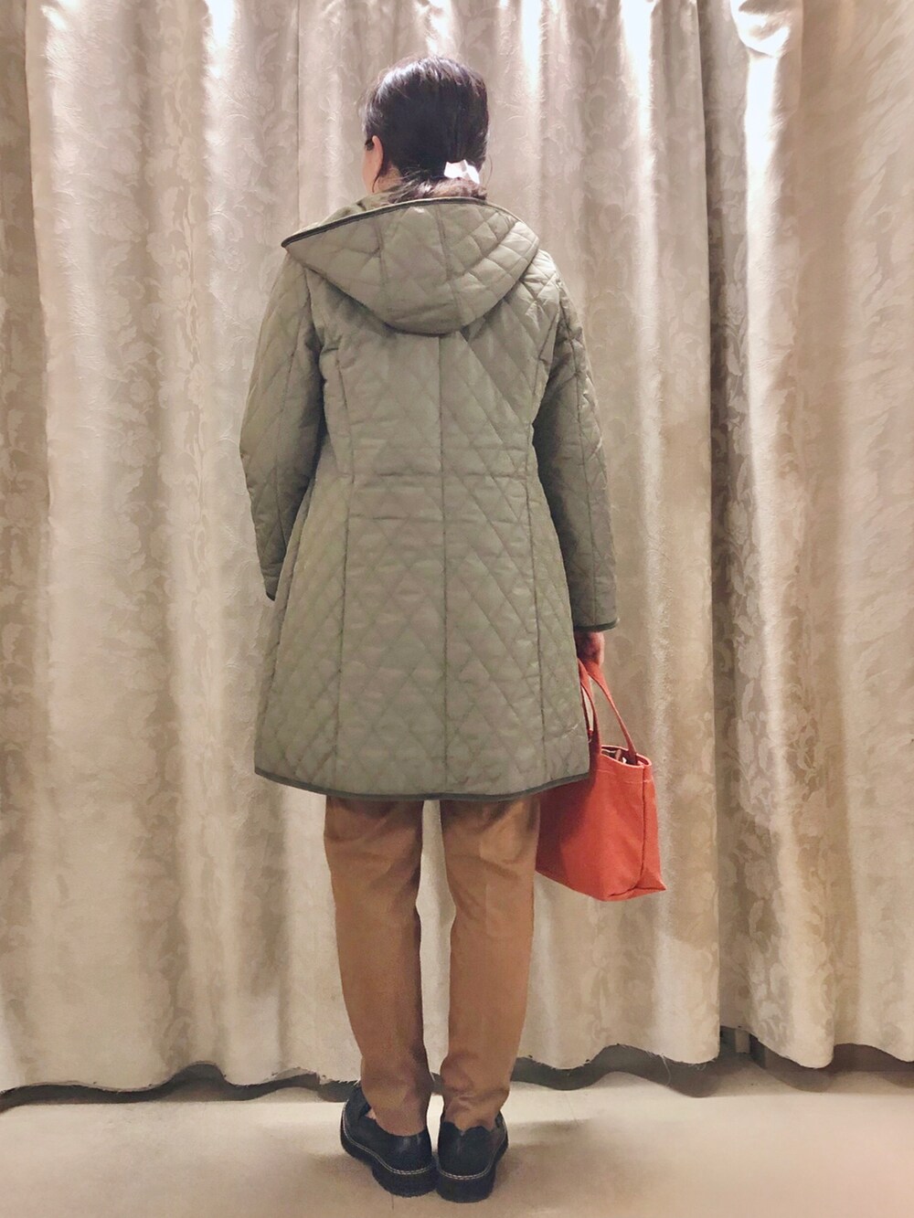 オレンジ系のトートバッグ、グリーン系のその他アウター、ホワイト系のスウェットを着用したレディースの秋コーディネートの3枚目の写真