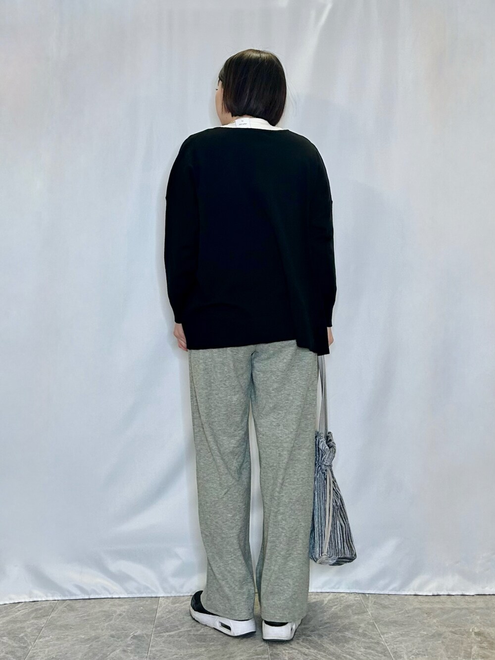 グリーン系のその他パンツ、ブラック系のニット/セーター、ホワイト系のTシャツ/カットソーを着用したレディースの冬コーディネートの3枚目の写真