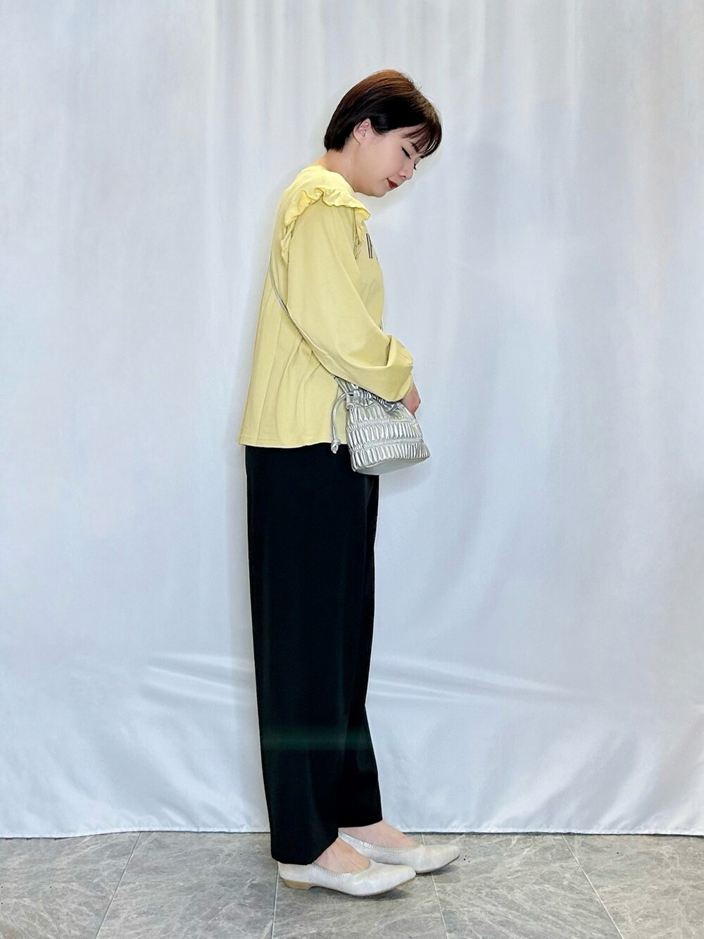 イエロー系のTシャツ/カットソー、ブラック系のその他パンツ、ゴールド系のその他シューズを着用したレディースの春コーディネートの2枚目の写真