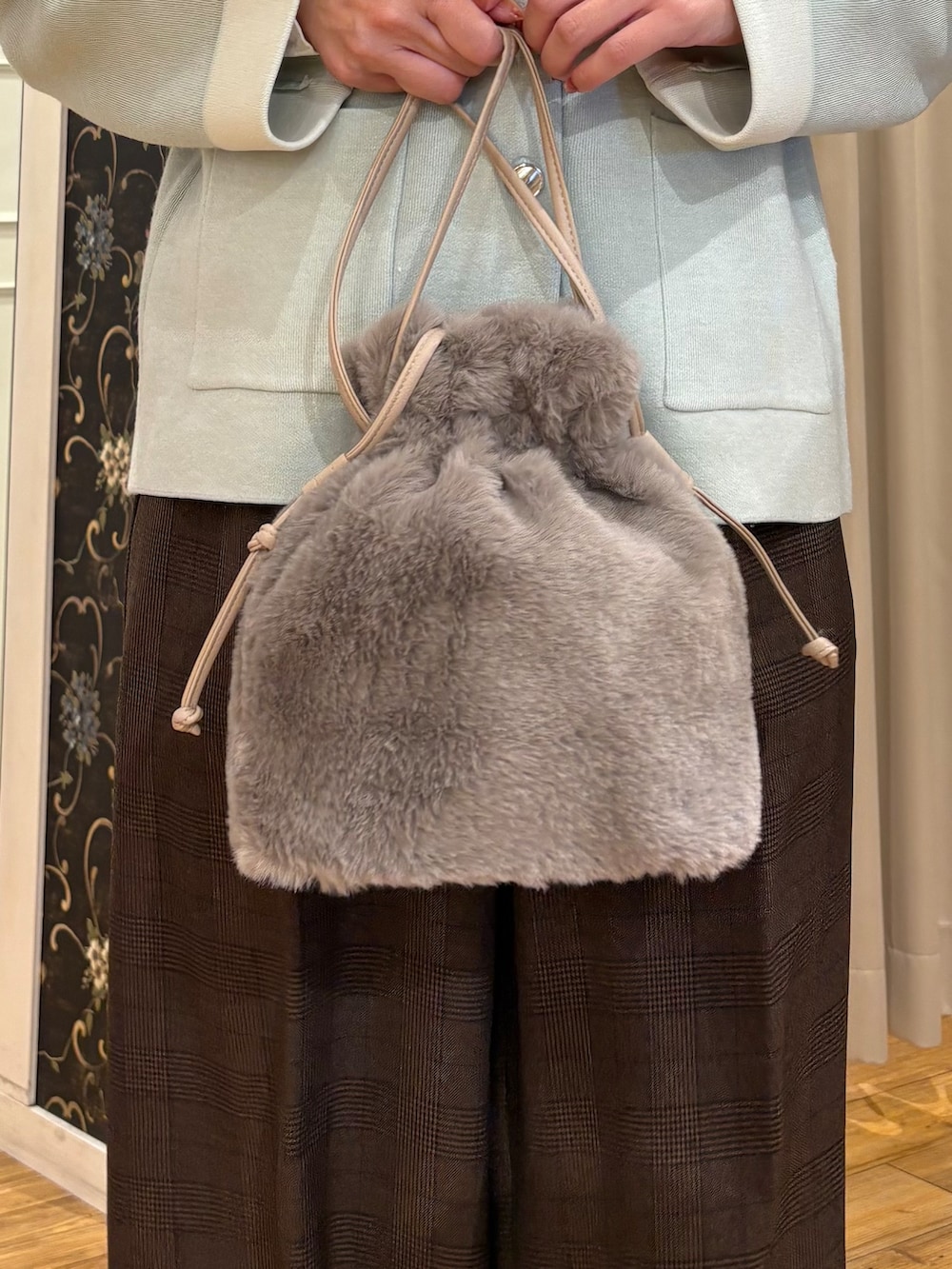 イエロー系のニット/セーター、ブラウン系のその他パンツ、ブラック系のブーツを着用したレディースの秋コーディネートの5枚目の写真