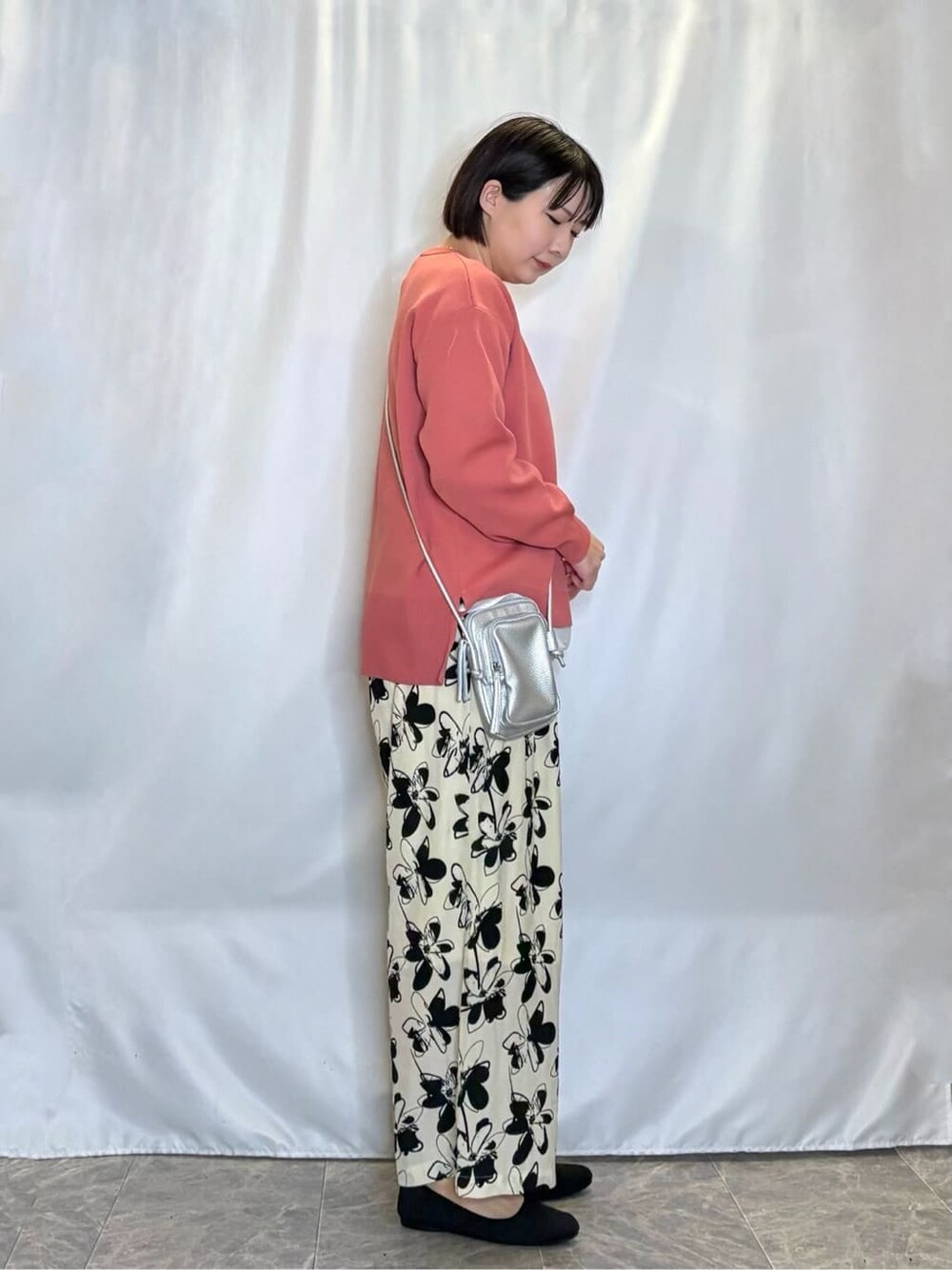 ピンク系のニット/セーター、ベージュ系のその他パンツ、ブラック系のパンプスを着用したレディースの春コーディネートの2枚目の写真