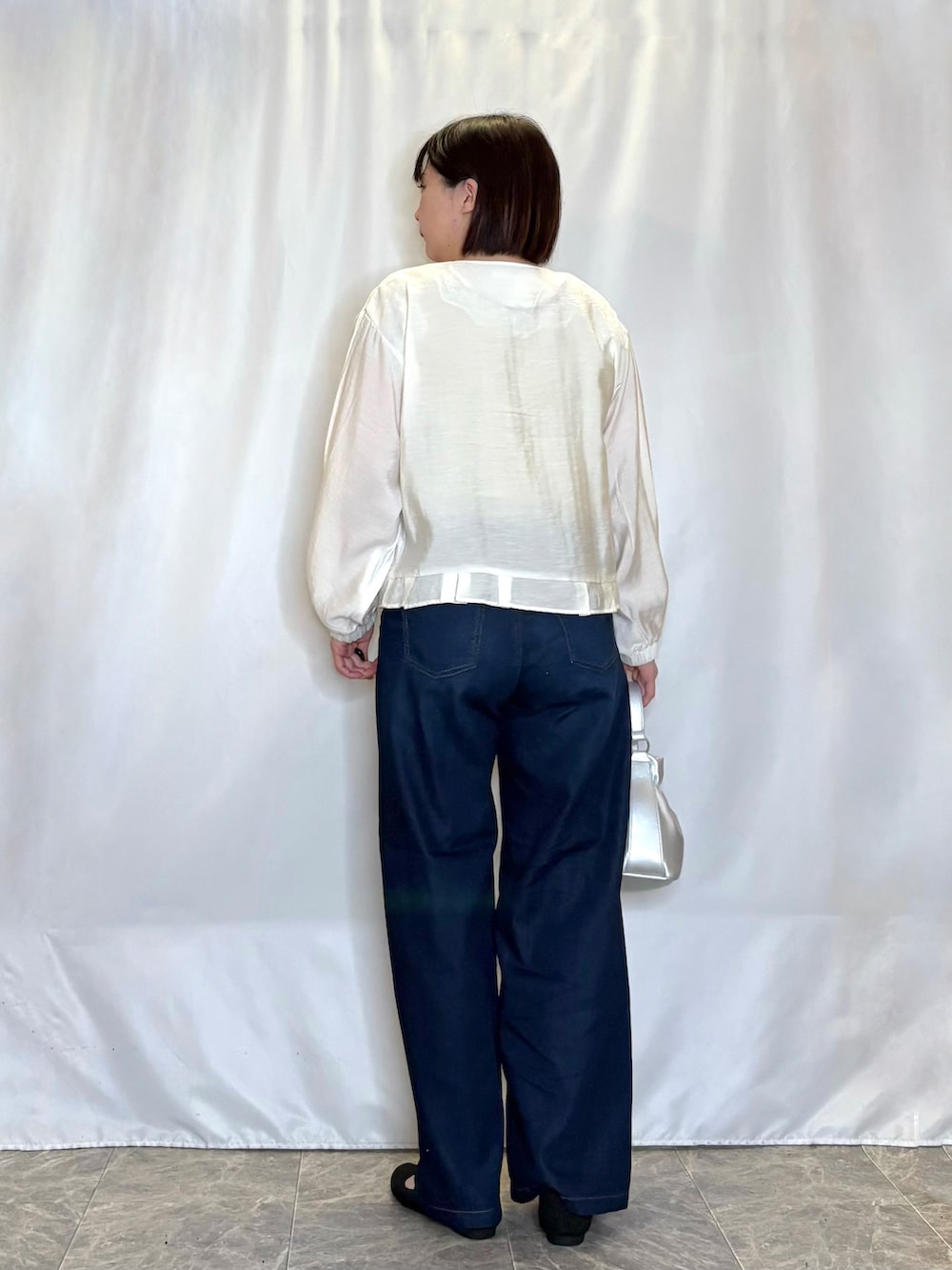 ホワイト系のブルゾン、イエロー系のタンクトップ、ブルー系のその他パンツを着用したレディースの春コーディネートの3枚目の写真