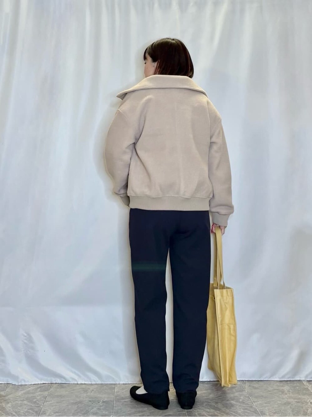 ホワイト系のニット/セーター、ブルー系のワンピース、ベージュ系のブルゾンを着用したレディースの冬コーディネートの3枚目の写真