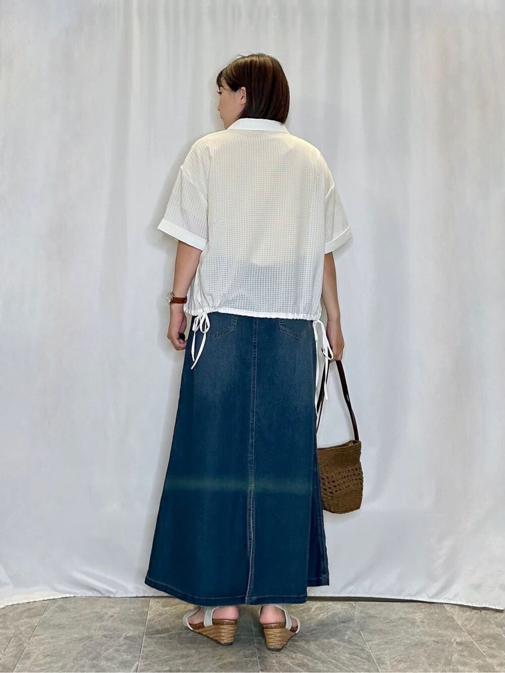 ホワイト系のシャツ/ブラウス、イエロー系のTシャツ/カットソー、ブルー系のデニムスカートを着用したレディースの夏コーディネートの3枚目の写真
