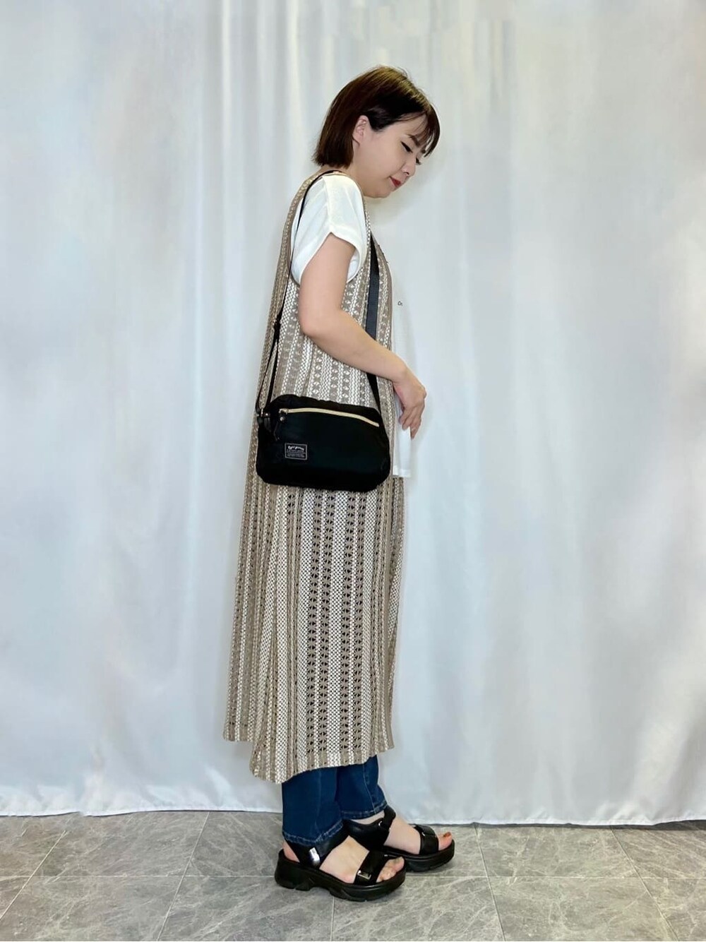 ブルー系のデニムパンツを着用したレディースの春コーディネートの2枚目の写真