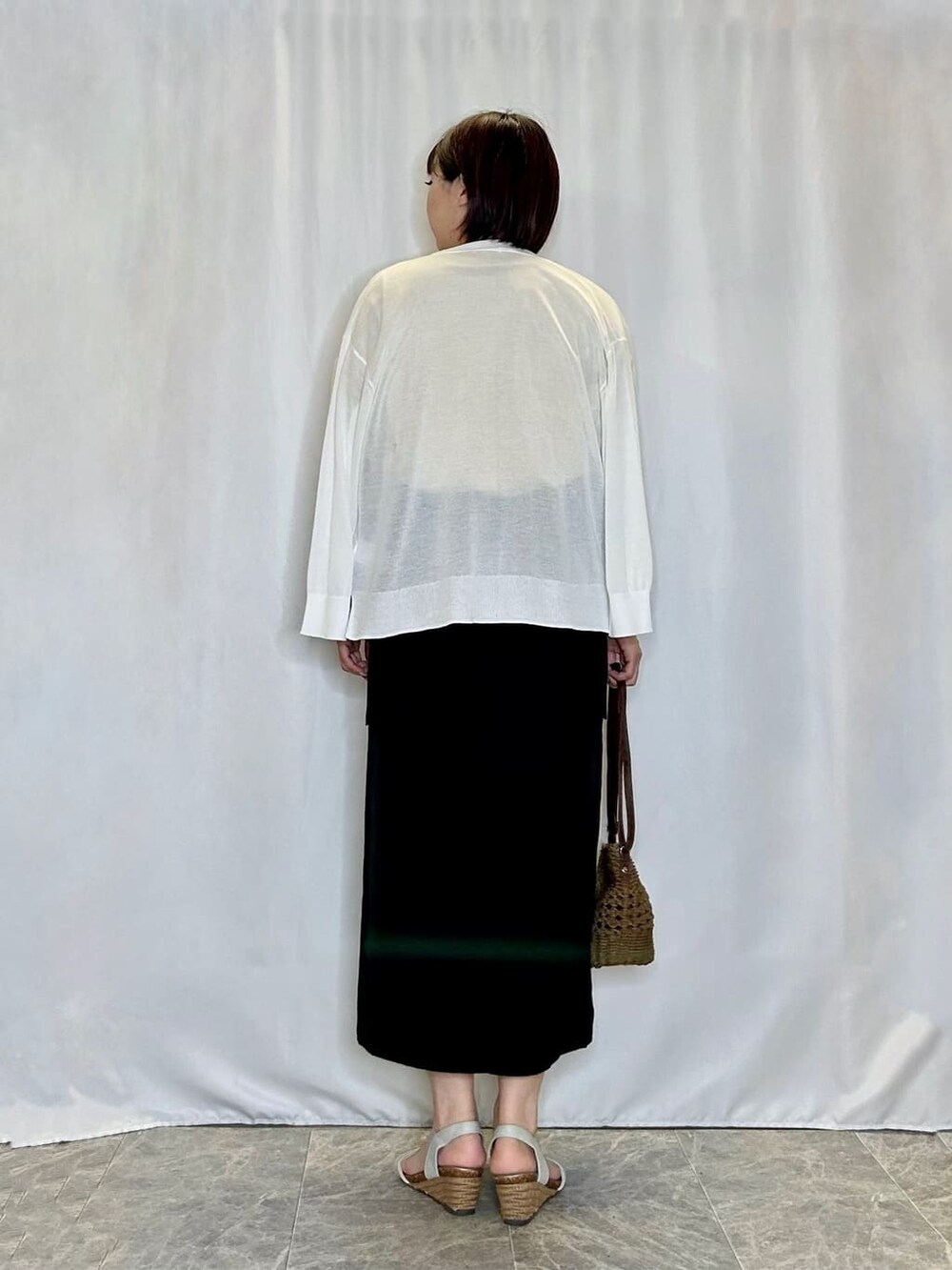 ホワイト系のカーディガン/ボレロ、イエロー系のTシャツ/カットソー、ブラック系のスカートを着用したレディースの夏コーディネートの3枚目の写真