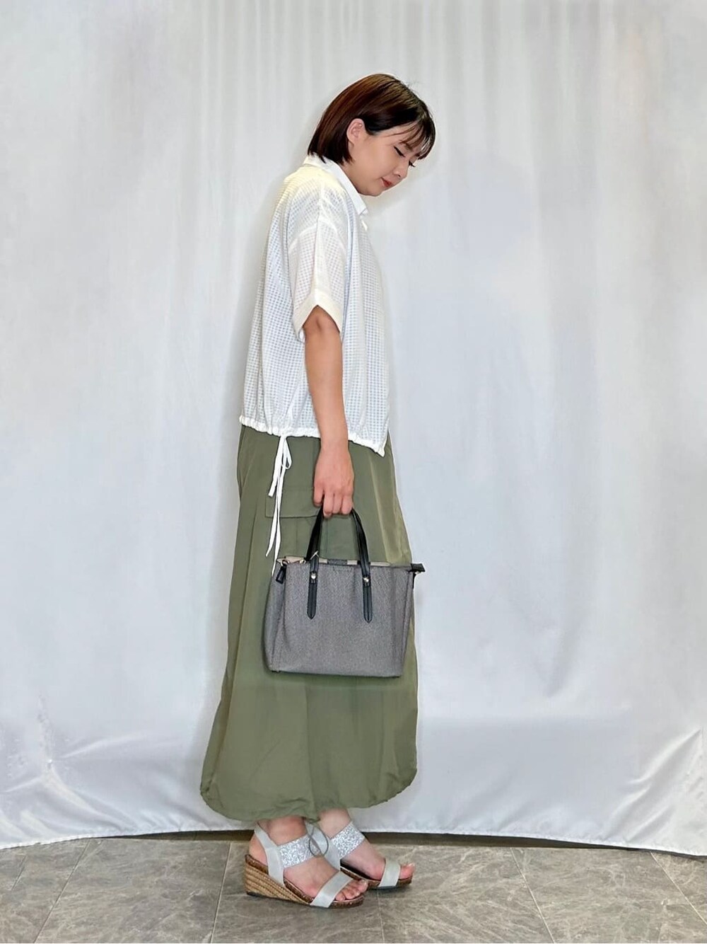 ホワイト系のシャツ/ブラウス、ブラウン系のTシャツ/カットソー、グリーン系のスカートを着用したレディースの夏コーディネートの2枚目の写真