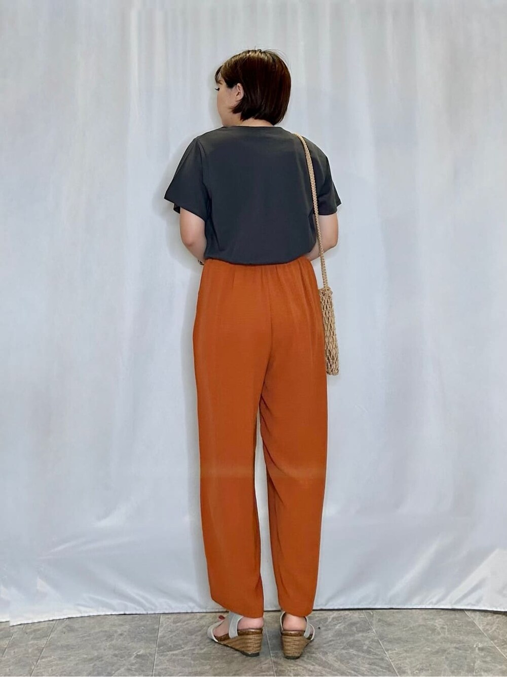 グレー系のTシャツ/カットソー、オレンジ系のその他パンツ、シルバー系のサンダルを着用したレディースの夏コーディネートの3枚目の写真