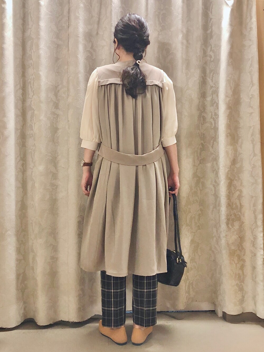 イエロー系のパンプス、ベージュ系のベスト、ホワイト系のTシャツ/カットソーを着用したレディースの秋コーディネートの3枚目の写真