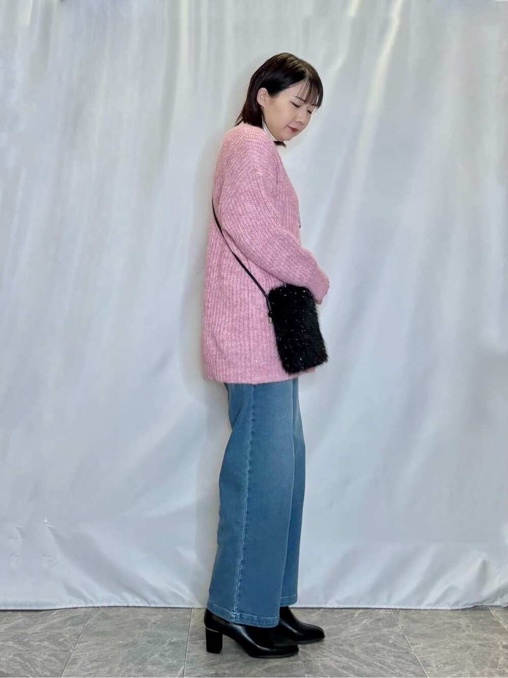 ピンク系のチュニック、ホワイト系のチュニック、ブルー系のデニムパンツを着用したレディースの冬コーディネートの2枚目の写真