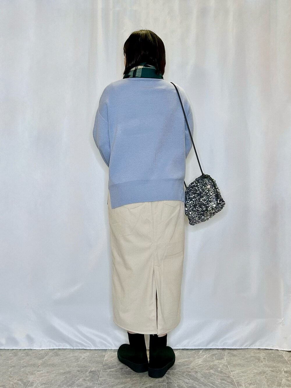 ブラック系のブーツ、ベージュ系のスカート、ブルー系のニット/セーターを着用したレディースの冬コーディネートの3枚目の写真