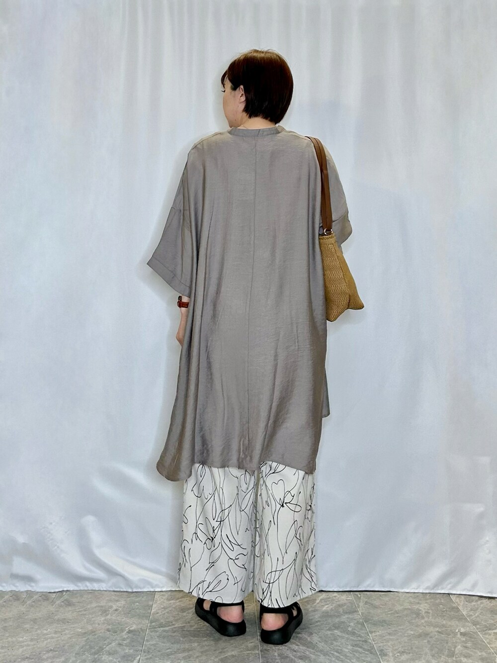 ブラック系のサンダル、ホワイト系のその他パンツ、ベージュ系のショルダーバッグを着用したレディースの春コーディネートの3枚目の写真