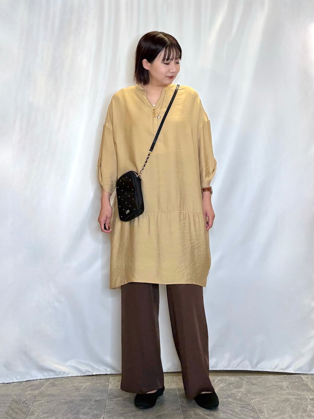 イエロー系のワンピース、ホワイト系のタンクトップ、ブラウン系のその他パンツを着用したレディースの夏コーディネートの2枚目の写真