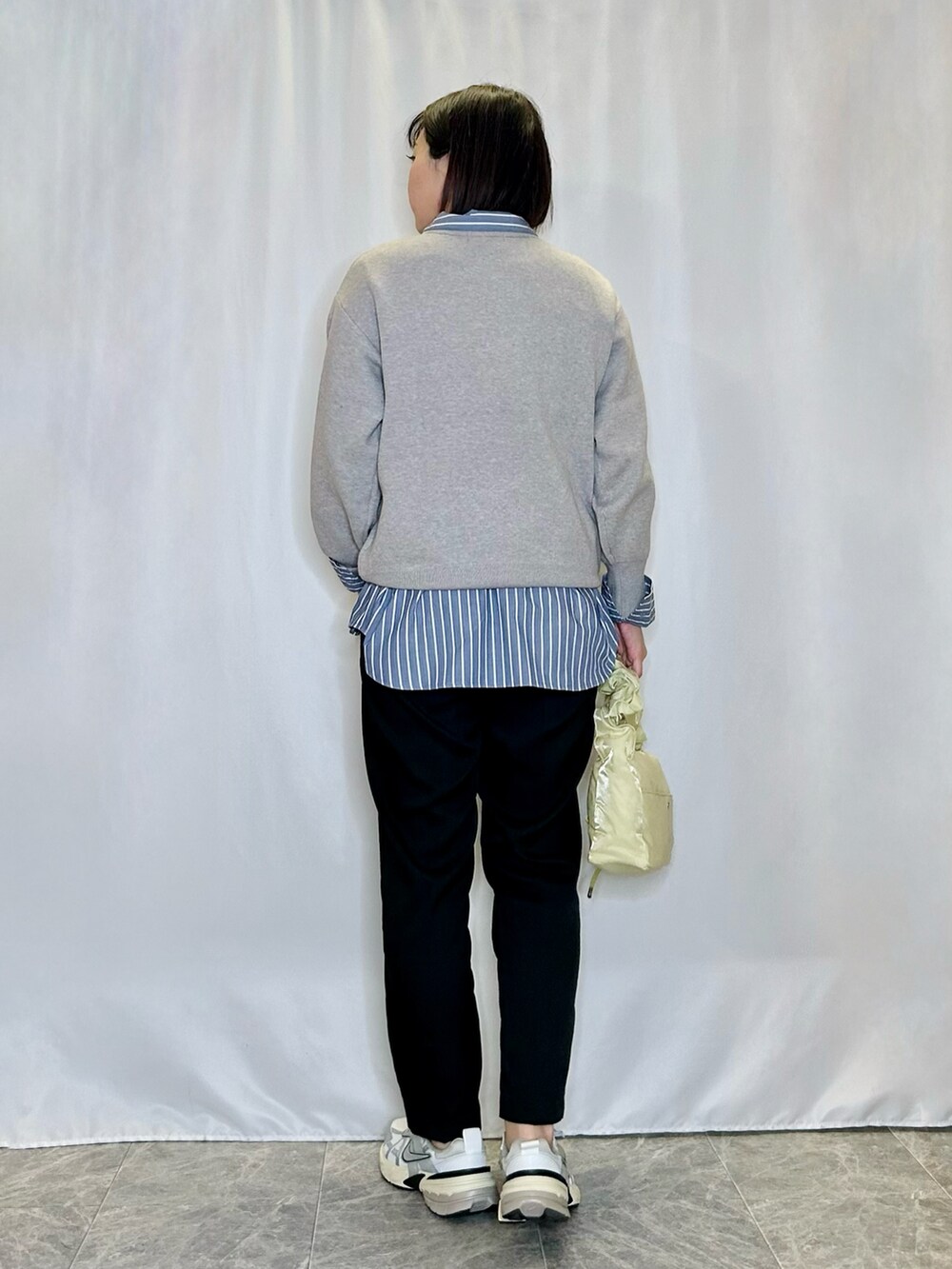 ブラック系のその他パンツ、イエロー系のショルダーバッグ、グレー系のニット/セーターを着用したレディースの冬コーディネートの3枚目の写真