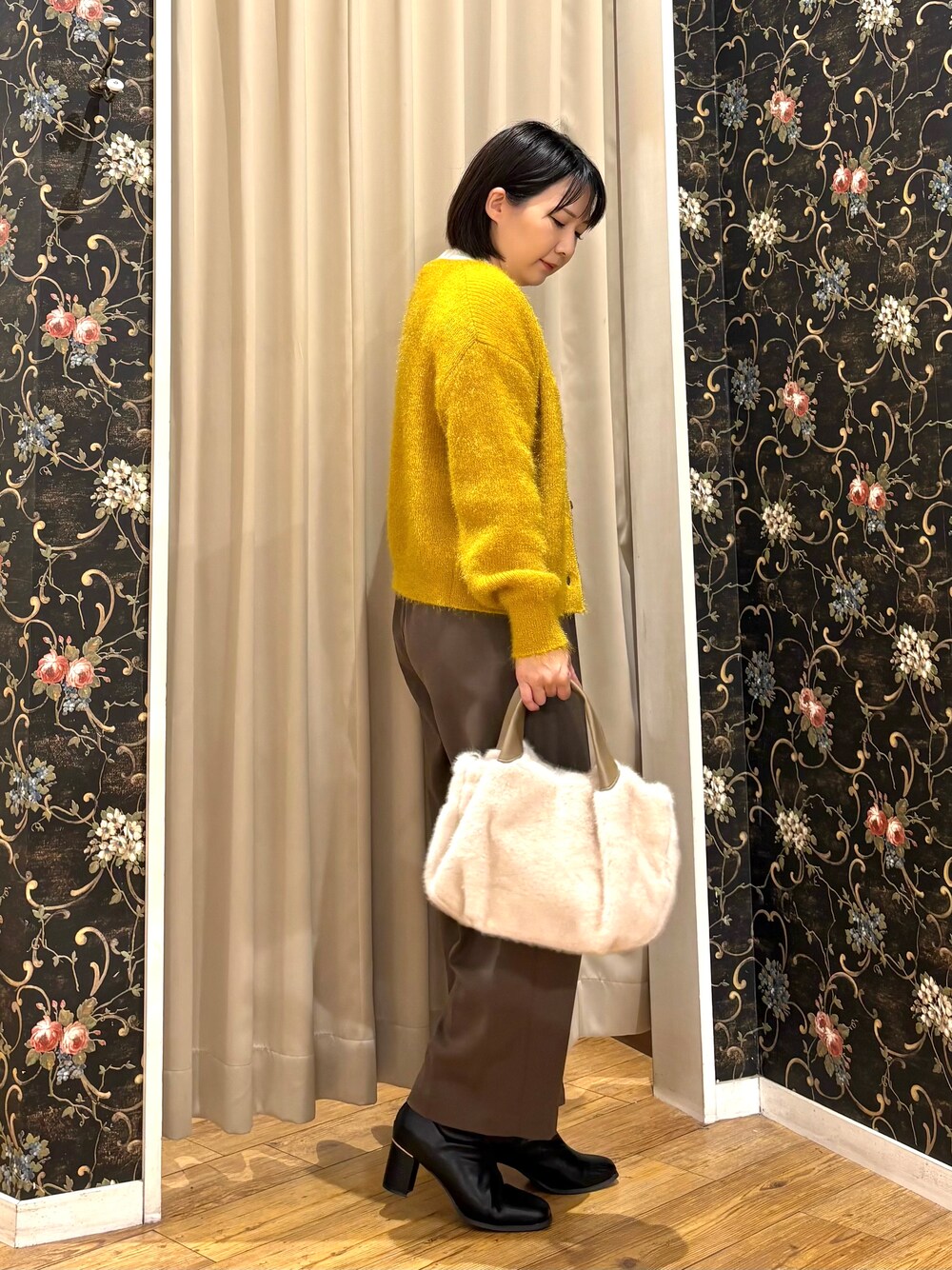 イエロー系のカーディガン/ボレロ、ホワイト系のニット/セーター、ブラウン系のその他パンツを着用したレディースの秋コーディネートの2枚目の写真