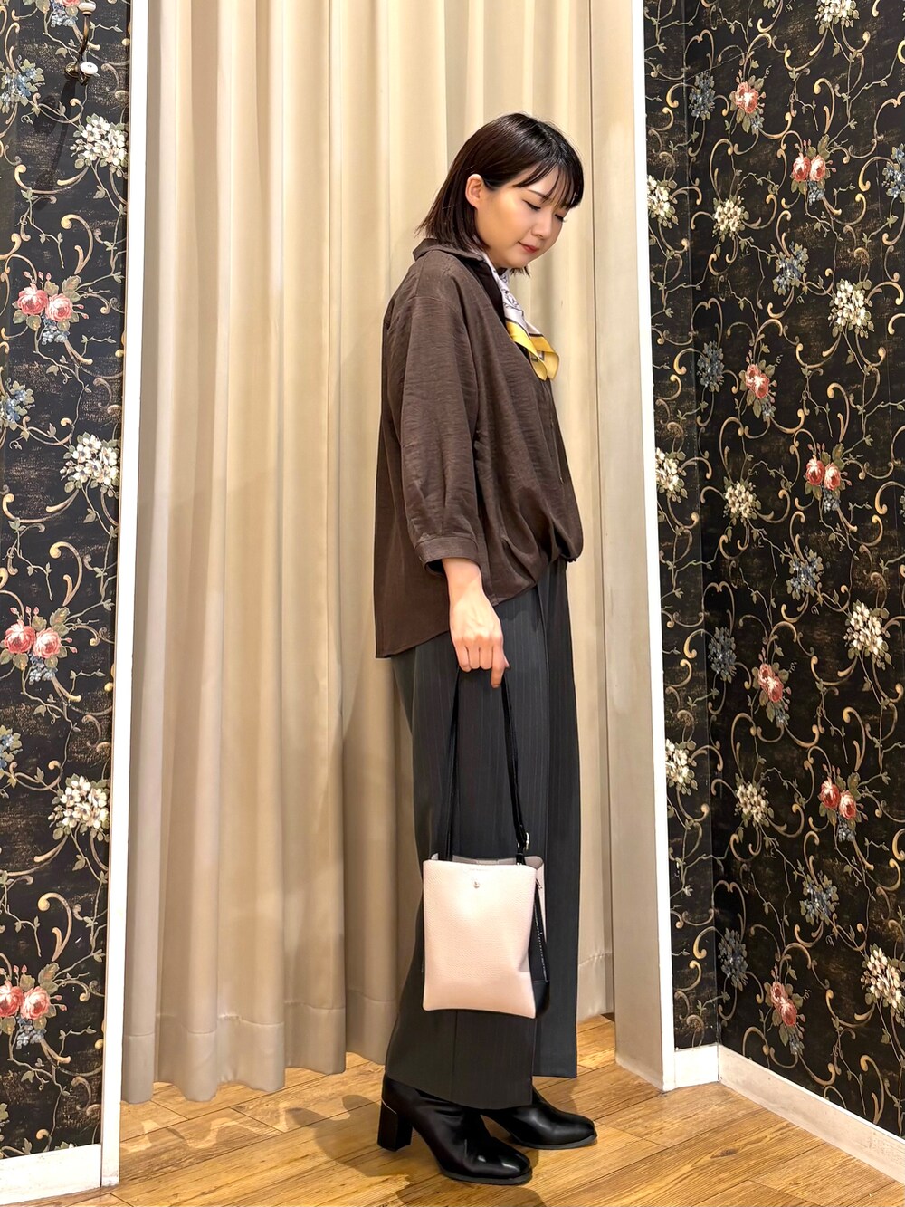 ブラウン系のシャツ/ブラウス、グレー系のその他パンツ、ブラック系のブーツを着用したレディースの秋コーディネートの2枚目の写真