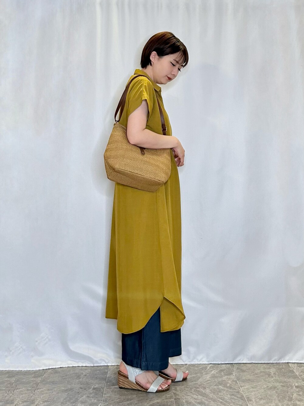 シルバー系のサンダル、イエロー系のワンピース、ブルー系のその他パンツを着用したレディースの春コーディネートの2枚目の写真