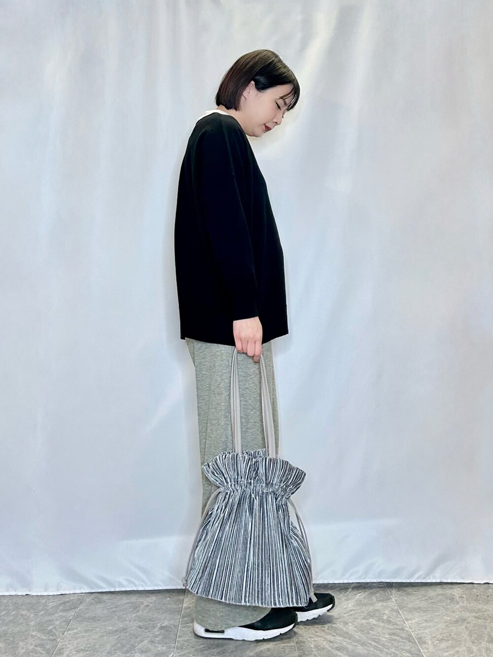 グリーン系のその他パンツ、ブラック系のニット/セーター、ホワイト系のTシャツ/カットソーを着用したレディースの冬コーディネートの2枚目の写真