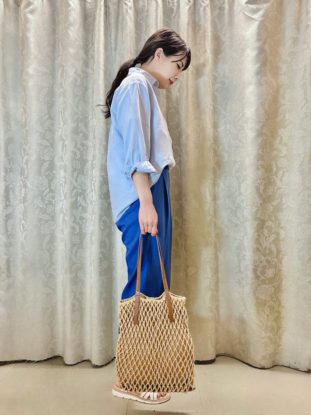 ブラウン系のトートバッグ、ホワイト系のサンダル、ホワイト系のTシャツ/カットソーを着用したレディースの春コーディネートの2枚目の写真