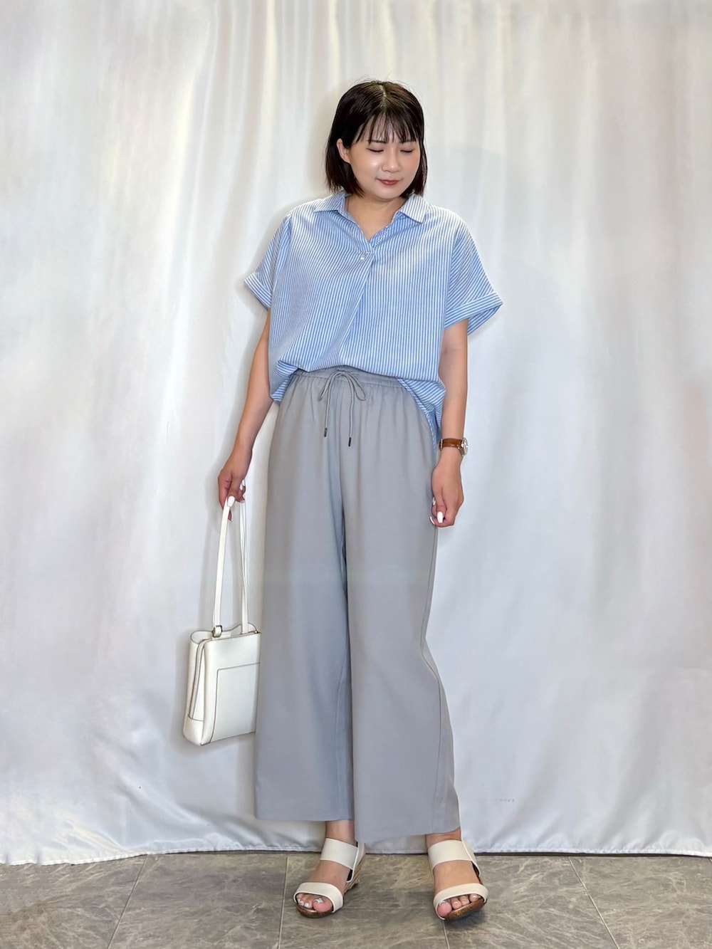 ブルー系のシャツ/ブラウス、グレー系のその他パンツ、ホワイト系のサンダルを着用したレディースの夏コーディネートの2枚目の写真