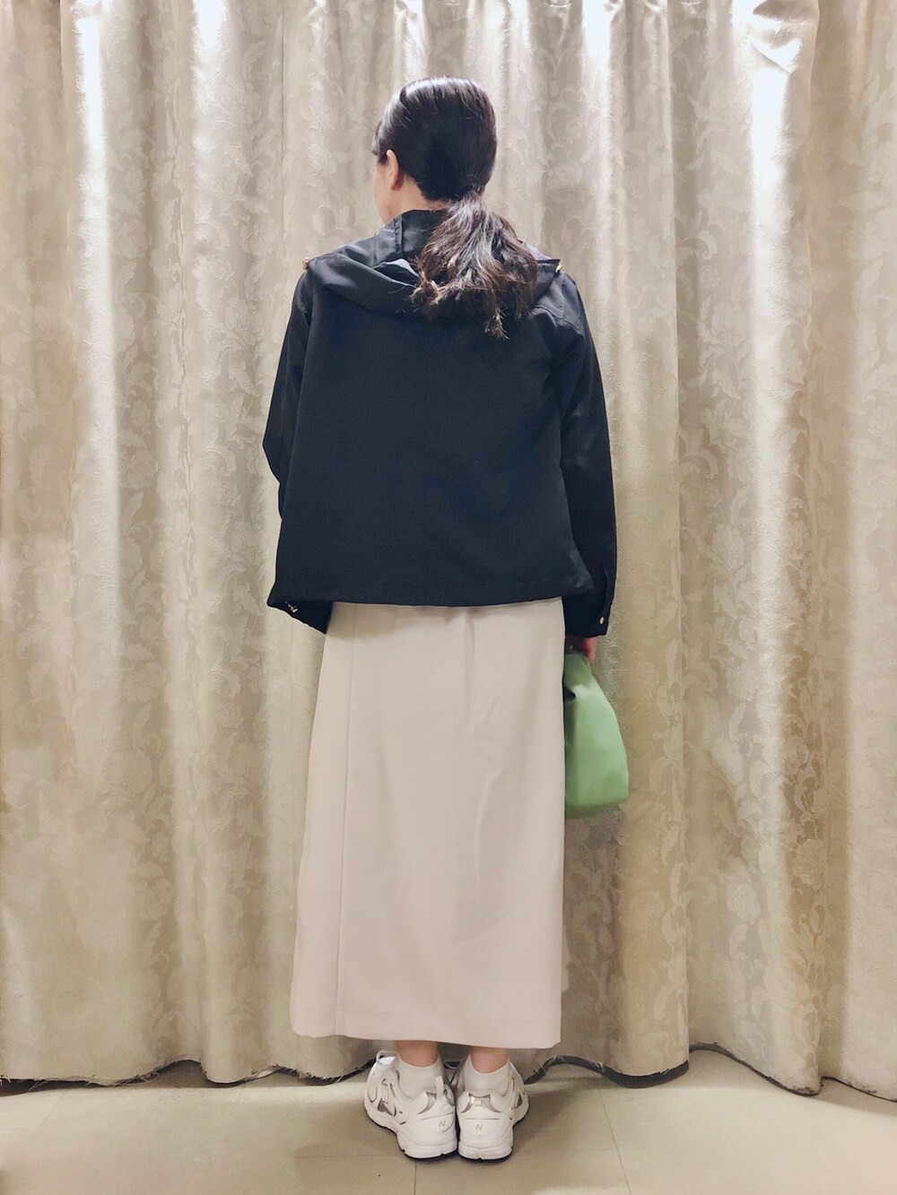 ホワイト系のスカート、ブルー系のブルゾン、ホワイト系のスニーカーを着用したレディースの春コーディネートの3枚目の写真