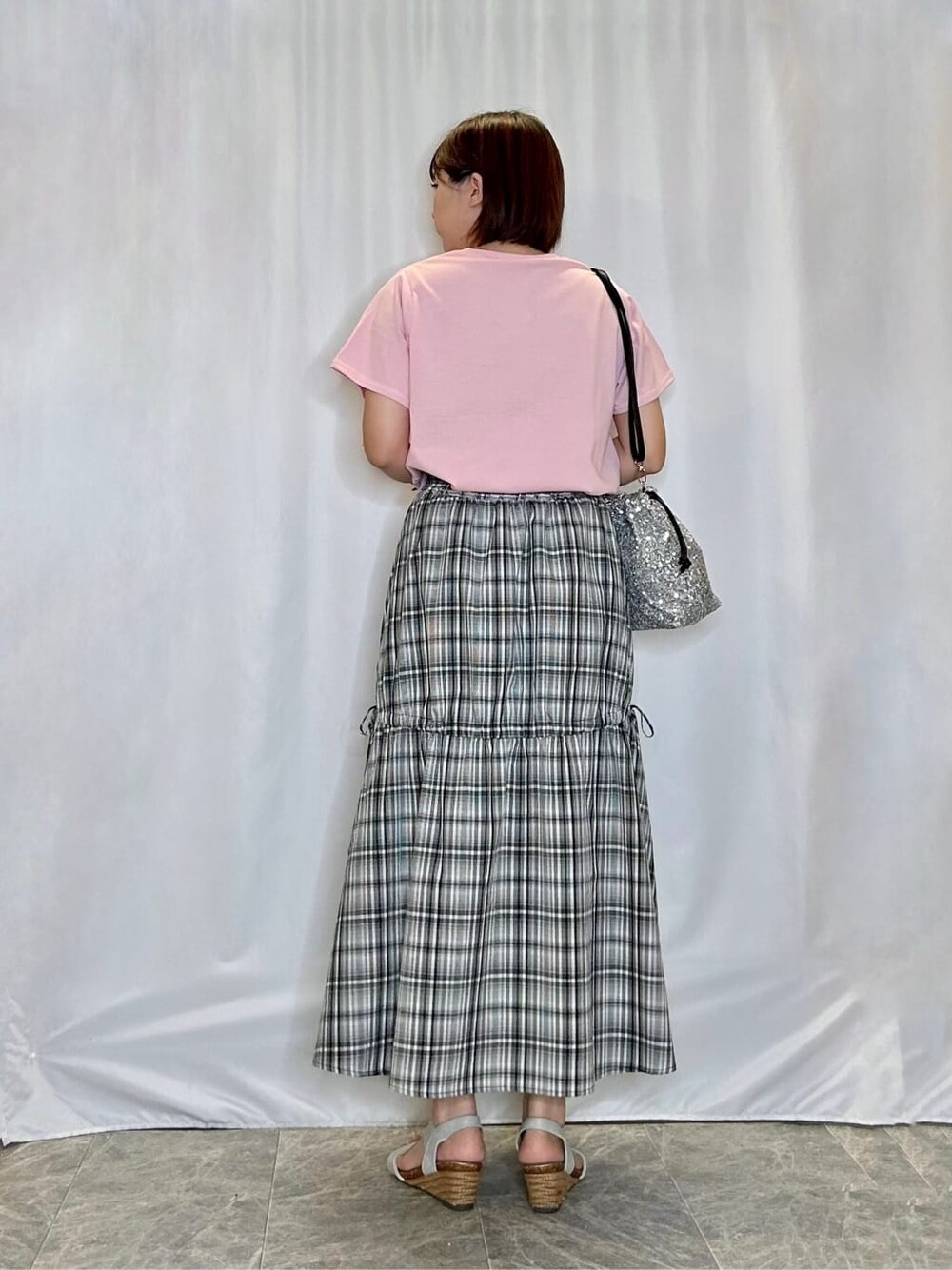 ピンク系のTシャツ/カットソー、ブラック系のスカート、シルバー系のサンダルを着用したレディースの夏コーディネートの3枚目の写真