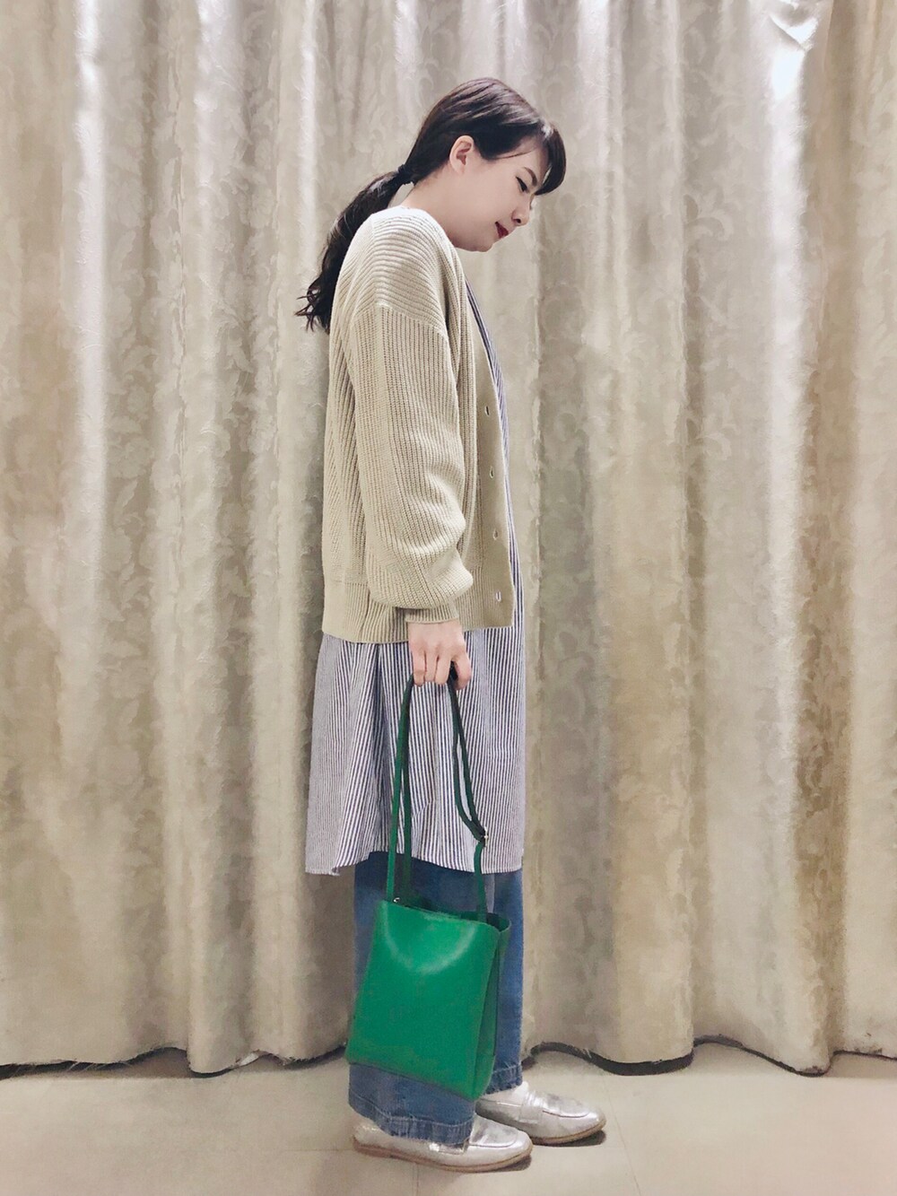 ベージュ系のカーディガン/ボレロ、ブルー系のワンピース、シルバー系のスニーカーを着用したレディースの春コーディネートの2枚目の写真