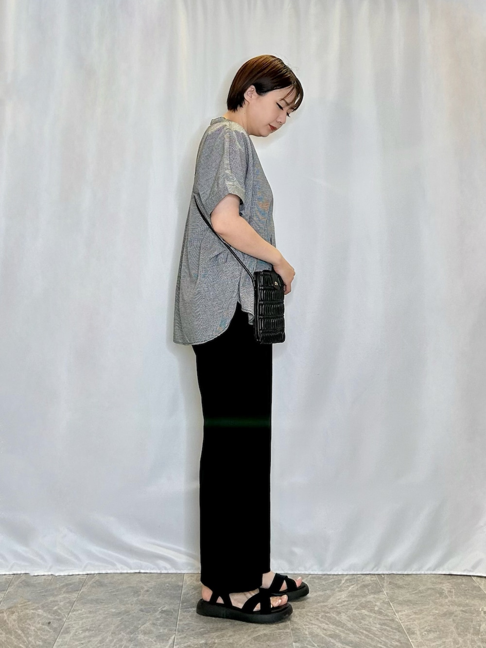 ブラック系のシャツ/ブラウス、ブラック系のショルダーバッグ、ブラック系のサンダルを着用したレディースの春コーディネートの2枚目の写真