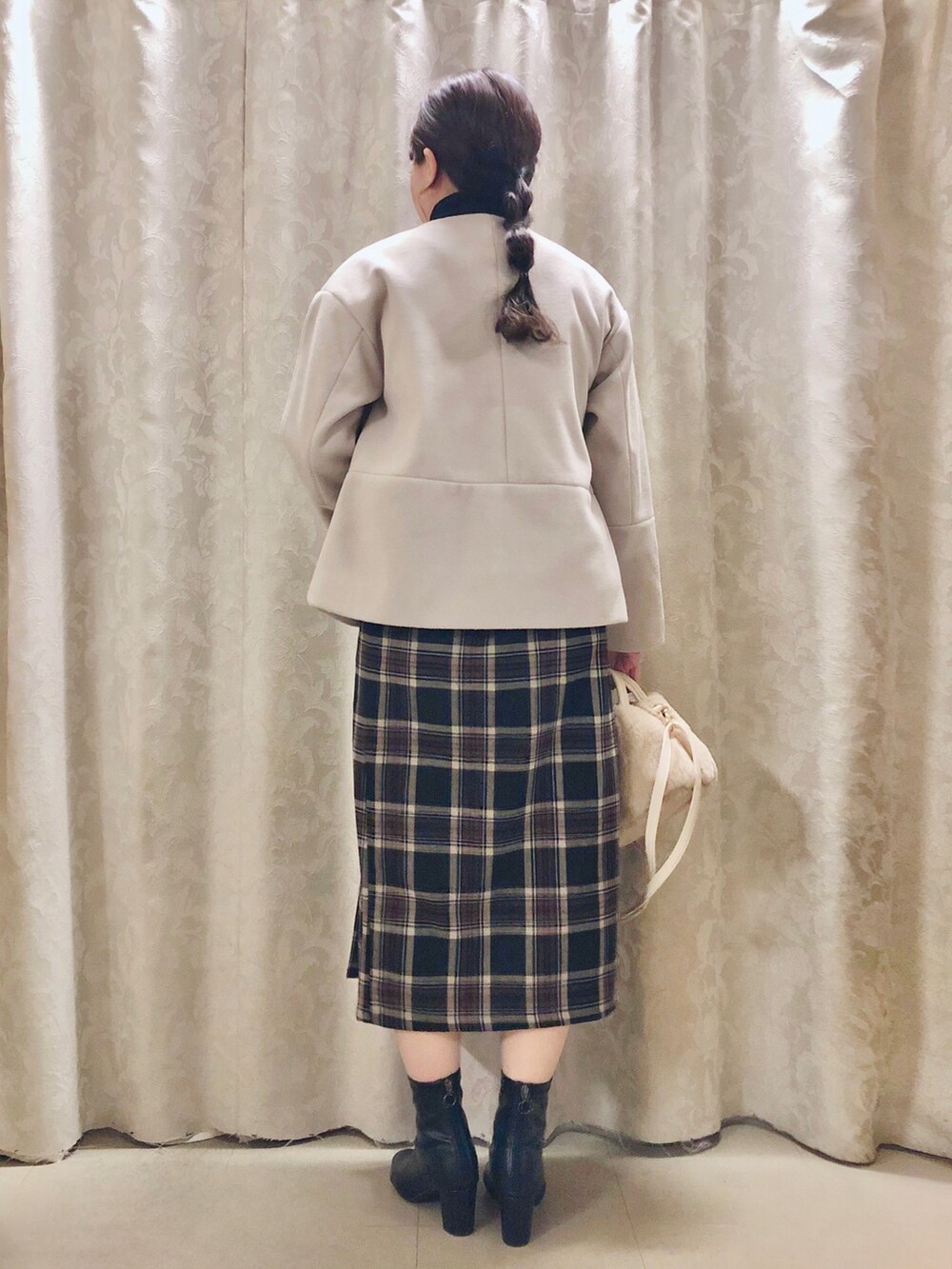 ブラック系のニット/セーター、ブラック系のスカート、ブラック系のブーツを着用したレディースの秋コーディネートの3枚目の写真