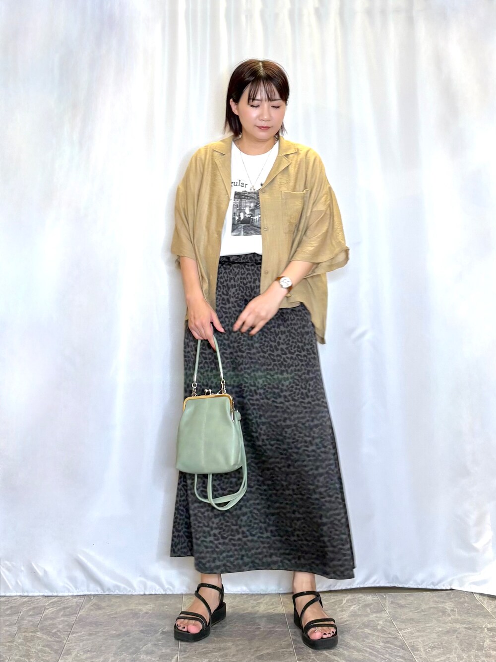 ブラウン系のシャツ/ブラウス、ホワイト系のTシャツ/カットソー、グレー系のスカートを着用したレディースの夏コーディネートの2枚目の写真
