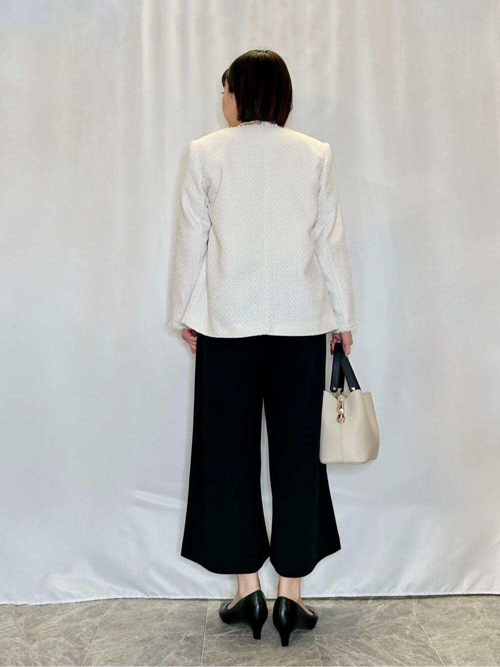 ベージュ系のノーカラージャケット、ホワイト系のシャツ/ブラウス、ブラック系のその他パンツを着用したレディースの冬コーディネートの3枚目の写真