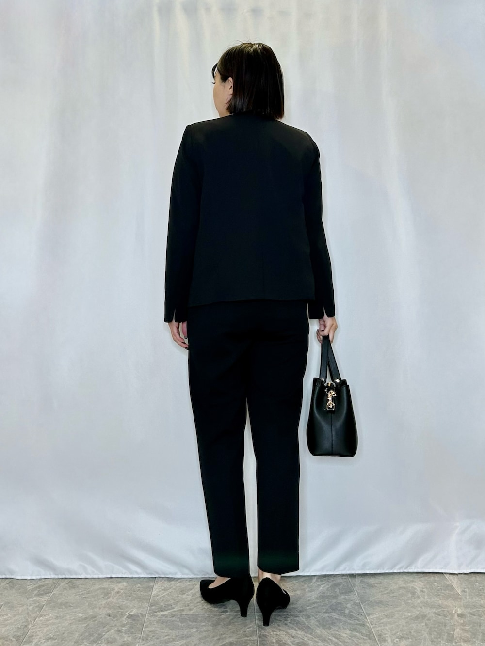 ブラック系のパンプス、ホワイト系のシャツ/ブラウス、ブラック系のトートバッグを着用したレディースの冬コーディネートの3枚目の写真