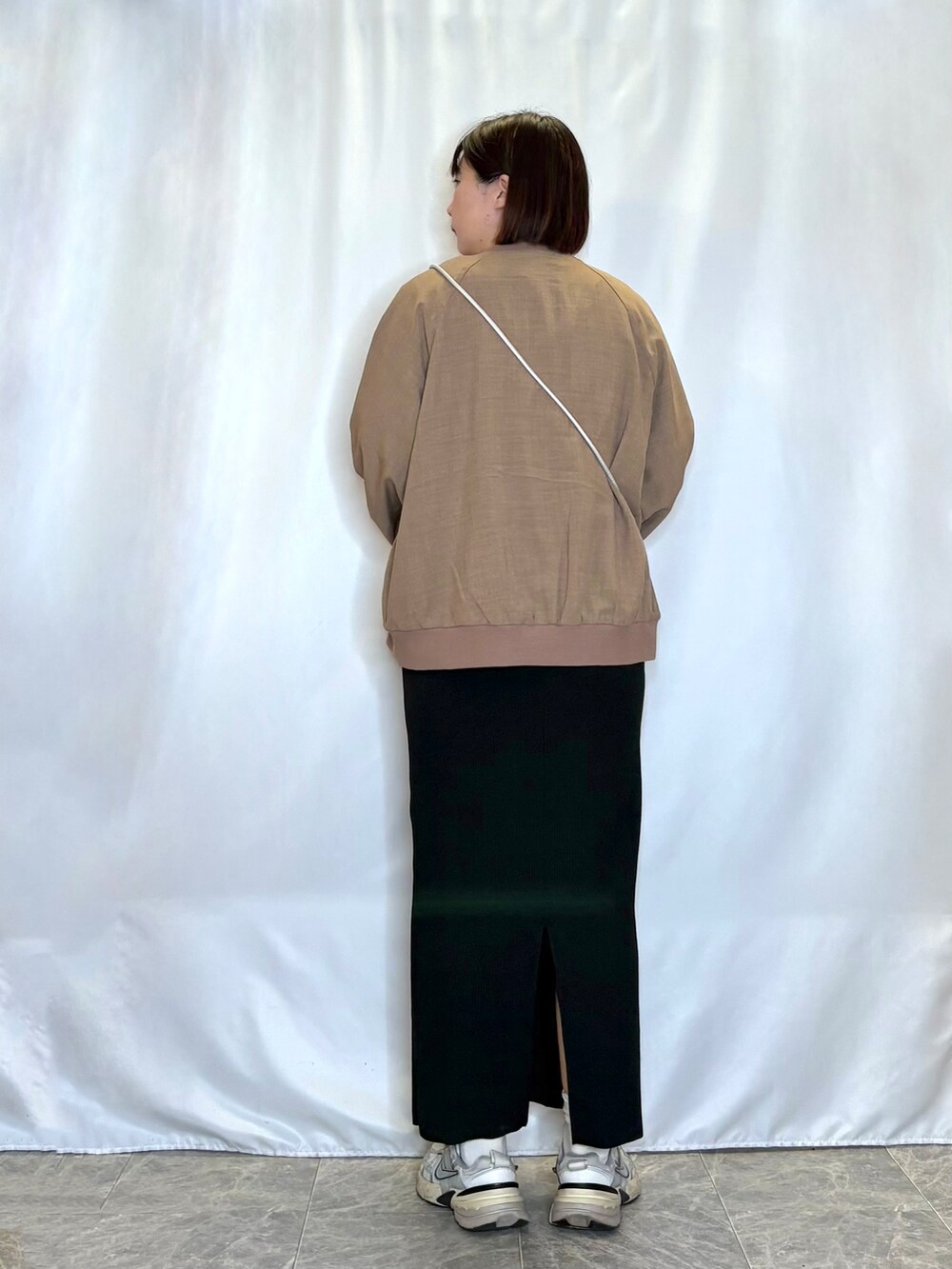 イエロー系のブルゾン、ホワイト系のTシャツ/カットソー、ブラック系のスカートを着用したレディースの春コーディネートの3枚目の写真
