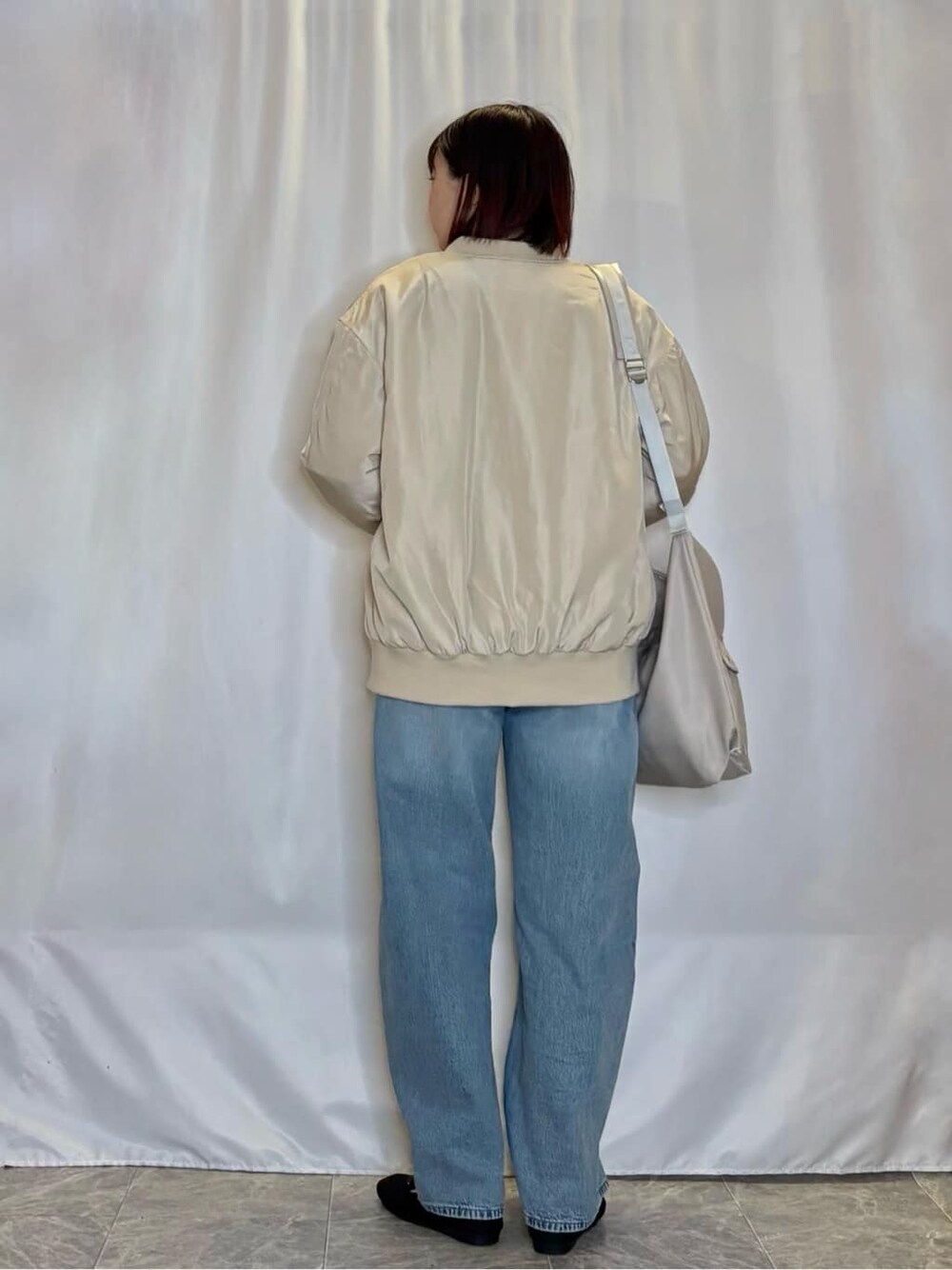ベージュ系のブルゾン、ブラック系のTシャツ/カットソー、ブルー系のデニムパンツを着用したレディースの冬コーディネートの3枚目の写真
