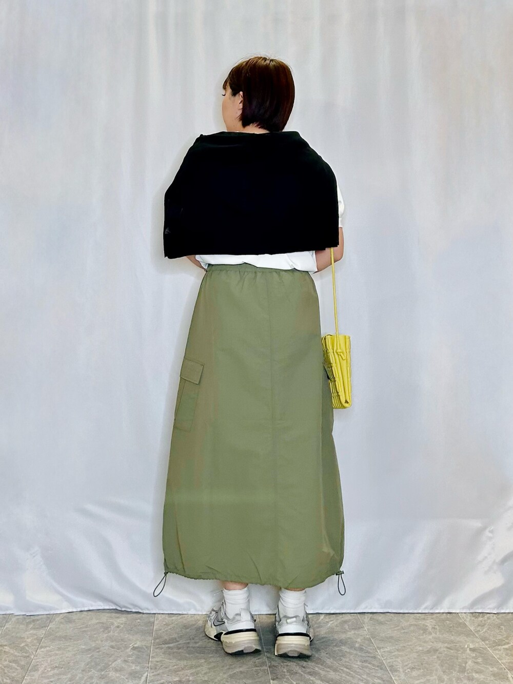 グリーン系のスカート、ホワイト系のTシャツ/カットソー、イエロー系のショルダーバッグを着用したレディースの春コーディネートの3枚目の写真